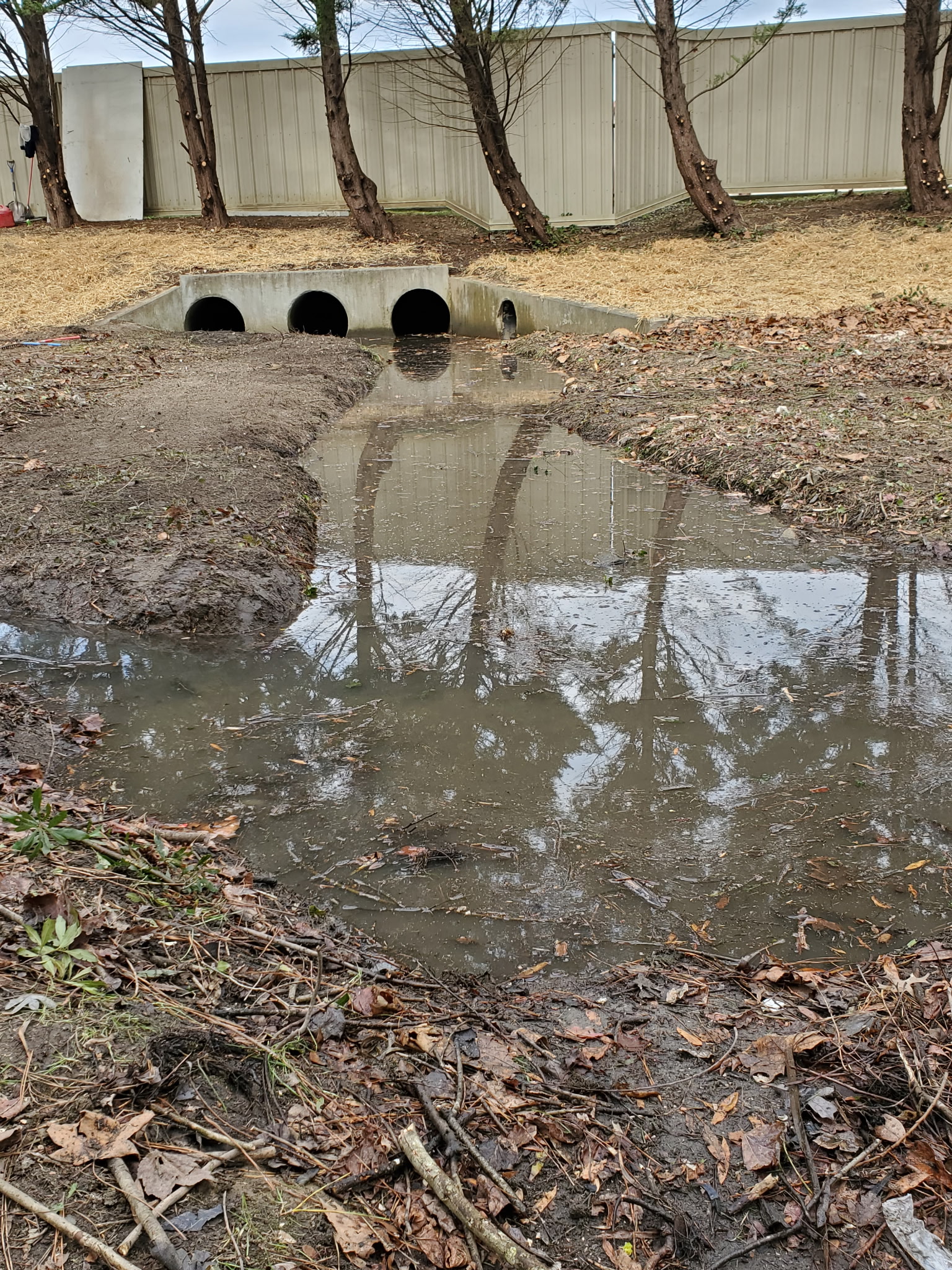 Flooded culvert outfall with standing water and erosion from neglected maintenance
